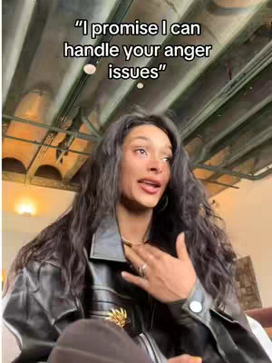 A woman with long, dark hair and a black leather jacket is centered in the frame. Text overlayed at the top says, "I promise I can handle your anger issues." The woman is looking up and to her right with a slightly open mouth and appears to be speaking. Her right hand is near her chest.