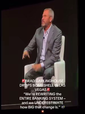The image shows a man sitting in a white chair on a stage, speaking into a microphone. Text overlays appear at the bottom and top, including a quote and the speaker's name.