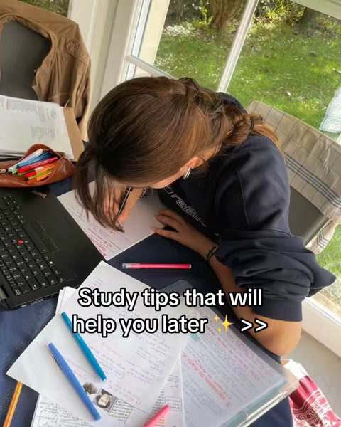 A young woman is studying at a table with a laptop, papers, and pens. The overlaying text says "Study tips that will help you later". A window with a green view of the outside provides a backdrop.