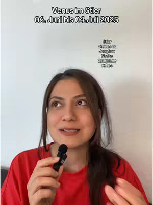 A woman with brown hair and a red shirt is holding a small microphone and gazing upwards with a thoughtful expression. Text overlaid near her head reads "Venus in Stier" above "06. Juni bis 04.Juli 2025,". and beneath this text is a list of zodiac signs.