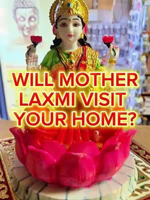 The image features a statue of the Hindu goddess Lakshmi, seated on a large lotus flower. The image is brightly lit with a focus on the central figure of Lakshmi. Text overlayed in a bright yellow font asks: 'Will Mother Lakshmi Visit Your Home?'