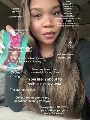 A woman with long brown hair and makeup is holding a tarot card with an illustration of a woman's face. Text bubbles with handwritten-style fonts surround her, suggesting a tarot reading or spiritual guidance. She is wearing a dark top.