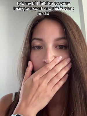 A medium shot features a woman with long brown hair, covering her mouth with her right hand. The background appears to be a neutral-colored wall.