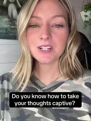 A light-skinned woman with blonde hair, wearing a camouflage shirt, is the central figure in the frame. The background is slightly blurred, featuring a hint of a painting and some decorations. A black bar at the bottom of the image contains white text, asking a question.