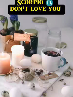 The cover image is a still life, featuring various objects on a white surface that could be a table or tabletop. In the center-left, a lit orange candle sits, casting warm light. To the right, a white mug with a blue handle contains a drink, possibly tea or coffee, with visible ingredients. A partially visible jar sits at the upper right, with visible light reflections. Several small white eggs and dark coffee grounds are also spread on the table. In the background, there are more jars, some with lids. In the upper left corner, there are small potted plants and flower buds. The items are neatly arranged, with a focus on mood and atmosphere. The overall presentation is soft and inviting.