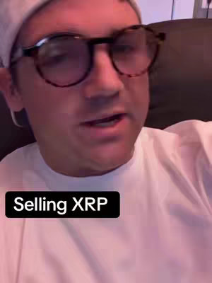 A man wearing glasses and a white shirt is looking at the camera while talking. There is a text overlay that says 'Selling XRP'.