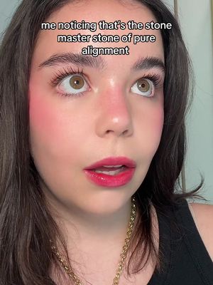 A close-up shot shows a young woman looking upwards with a surprised expression. Her face is made up with bright pink blush and red lipstick. Text is overlaid at the top.