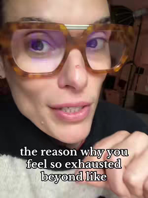 A close-up shot of a person wearing large, square, tortoise-shell glasses. The person's face is centered in the frame, with the focus on their eyes. A text overlay at the bottom reads, "the reason why you feel so exhausted beyond like". The background is slightly blurred and indistinct, suggesting an indoor setting.