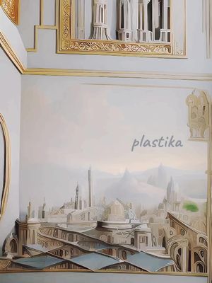 The image shows a stylized cityscape inside a room with walls and decorative elements. The main focus is on a detailed architectural rendering of a city, depicting various buildings and structures in a pale artistic rendering style. The city merges with background elements like sky and mountains in soft, muted colors. The overall composition is framed within a decorative interior, with architectural features adding depth and visual interest.