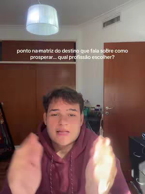 A man with light skin and short, dark hair is centered from the chest up, wearing a maroon hoodie. His hands are raised, palms out to the sides, as if presenting or gesturing. The background is a warm-toned room with a white lampshade and a closed wooden door. Text along the top spells out the video's goal.
