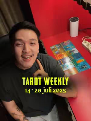 A man with dark hair and a mustache smiles at the camera while holding a card towards the bottom of the frame, with text overlay highlighting 'Tarot Weekly' and dates. The background includes a red table and white objects.