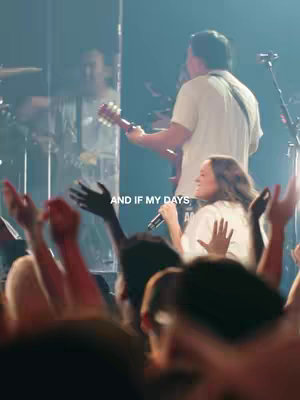 The cover image depicts a live performance on stage with a woman singing into a microphone while a man plays the guitar. Audience hands are raised in worship in the foreground.