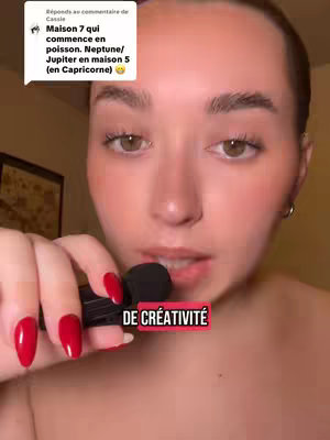 A close-up shot featuring a young woman's face, with a microphone held close to her lips. The background is slightly blurred, putting focus on her face and the microphone. She has light skin, brown eyes, and red nail polish. A text overlay is present at the bottom.