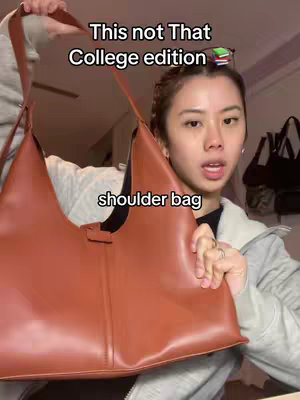 A woman stands holding a large brown shoulder bag in front of her. The background is a room with a ceiling fan and some items on a shelf. Text overlays read 'This not That College edition' and 'shoulder bag'.