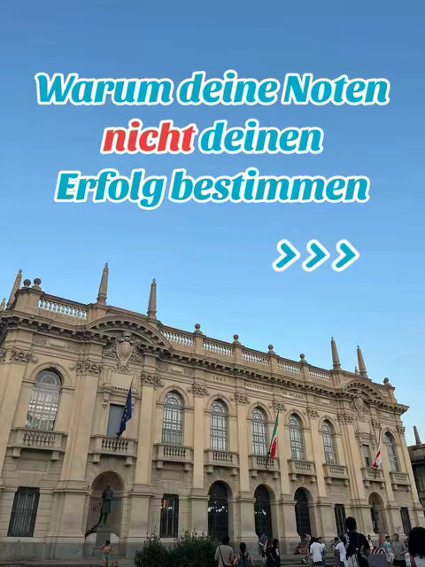 The image shows a historic building with a blue sky background and text overlayed in the center. The building is a light beige color and appears to have numerous windows and architectural details. Below the building, there is a crowd of people on the street. The text overlay asks a question in light blue fonts: "Warum deine Noten" (Why your grades), with the word "nicht" in red (not) and "deinen Erfolg bestimmen" (determine your success.) Then there are three arrows in white on the right.