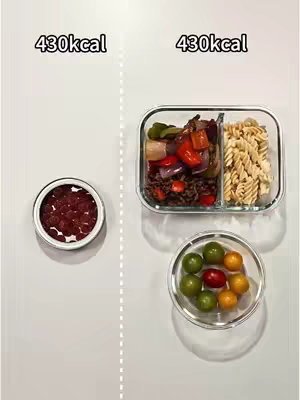 The image is a top-down shot featuring separate sections of food items. The layout is divided with a white line splitting the shot into two. On the left, there is a small bowl containing a red berry mixture, against a white background. On the right, a glass, divided container filled with colorful vegetables, a portion of fusilli pasta, and a small circular glass containing green and yellow tomatoes are displayed on a white surface. The background is solid white.