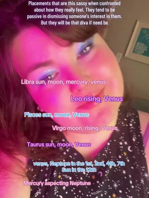 A selfie-style image featuring a woman's face with colorful makeup and overlaid text related to astrology placements. The background is blurred, with pink and purple lighting highlighting the subject. Text elements include astrological terms and descriptions.