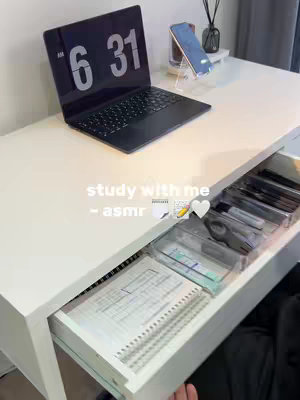 A well-lit desk with a laptop displaying 6:31, a smartphone on a stand, and a partially open drawer. The drawer reveals notebooks and stationery. Text overlays include 'study with me -asmr' and related emojis.