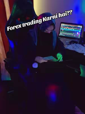 The image shows a person wearing a scarf sitting in a gaming chair in a dimly lit room. There is a laptop on a desk, displaying a financial chart. The person is holding some banknotes. The room has blue, purple, and green lights.