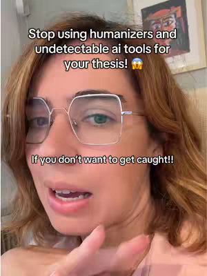 A selfie-style shot featuring a woman with auburn hair, wearing large square glasses, looking towards the camera and gesturing with her right hand. Above her are the text overlays. The background includes a blurred glimpse of artwork or decor.
