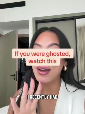 A woman with long dark hair and wearing a white top is facing the camera. A pink rectangle with white font overlays the top of the frame. The interior setting has a bed and door in the background to the left.