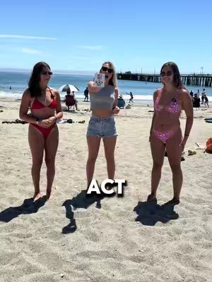 Three young women on a sunny beach. The woman in the center holds up a card with text. The word "ACT" is superimposed over their shadows. The ocean and a pier are visible in the background.