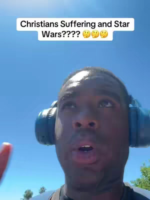 A man with dark skin is looking upwards with a neutral expression. He has short black hair, and is wearing blue headphones. The background is a clear blue sky. The hook text is white letters on black background.