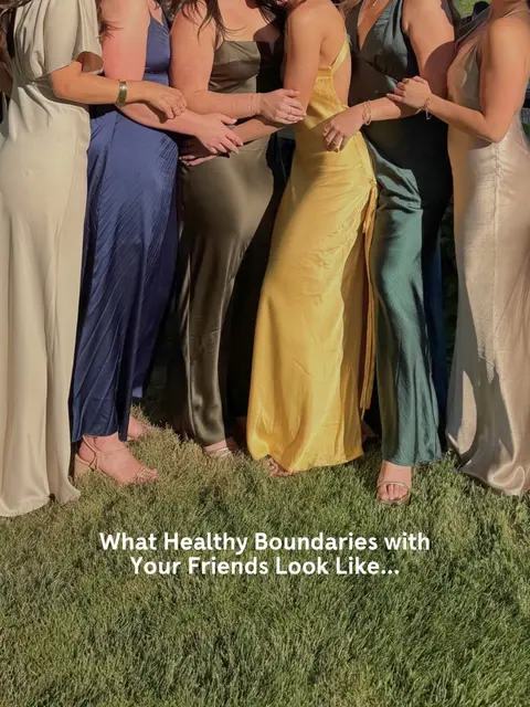 A photograph showing six women standing close together, arms intertwined across each other's backs. They are dressed in long, elegant dresses of varying colors including beige, navy, muted olive green, and yellow. They are standing on a grassy area. Text overlayed at the bottom reads: 'What Healthy Boundaries with Your Friends Look Like...'