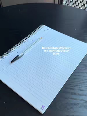 A top-down shot of a spiral-bound notebook with lined paper, a pen resting on it. The notebook is open, and the pen is positioned diagonally across the pages. The paper is white, with a light grid of lines visible. The background is a dark, possibly black, surface that appears to be a table or desk. The main text overlay is centered on the notebook page.