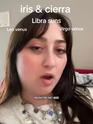 A selfie-style video cover image featuring a woman with dark hair and visible facial features, including her nose, mouth, and eyes. She is wearing a necklace and facing the camera with an open mouth, suggesting she is speaking or mid-sentence. Text overlays introduce the topic: "iris & cierra" and "Libra suns," with labels for Leo and Virgo placements. Additional text reads "OBSERVATION THAT I MADE" at the bottom, indicating this is her commentary.