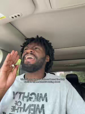 A man inside a car, looking up and to the right with a wide, expressive face, as if in an emotional moment. The background shows the car's interior.