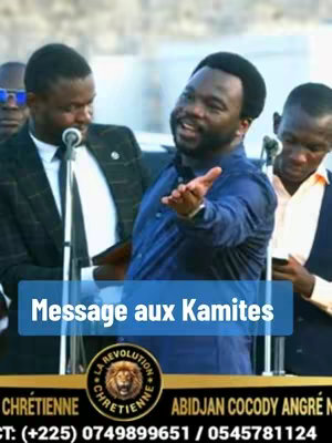 The image shows a man speaking in a public setting with a microphone in front of him, other men are standing behind him. A title with blue background is overlaid on the image with the text 'Message aux Kamites'. A logo that reads 'La Revolution Chretienne' is also overlaid in gold with a lion.