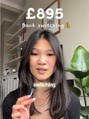 A woman holds a microphone with the word "switching" in a speech bubble overlaid on her. Behind her, a framed picture hangs on a wall and a partial bookshelf is visible, alongside a plant.