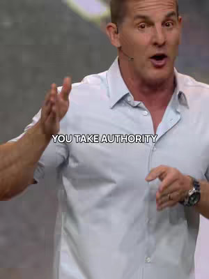 A man in a light blue shirt is gesturing with his hands, appearing to be speaking. Above him, a text overlay reads "YOU TAKE AUTHORITY."