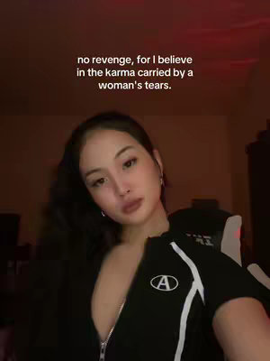 A woman with dark hair and light skin looks thoughtfully at the camera. Text overlayed on the image states, "no revenge, for I believe in the karma carried by a woman's tears."