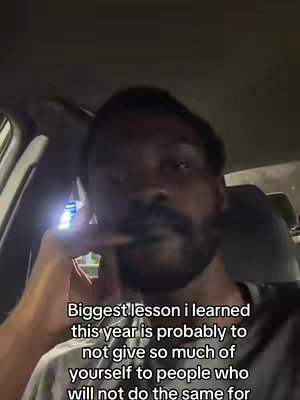 A selfie-style shot inside a vehicle showing a person. The person, a Black man, is in the foreground, looking directly at the camera with a somewhat serious expression. He has short, dark hair, a mustache and a goatee. The lighting appears to be dim. Above his head is a text overlay.