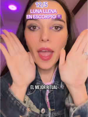 A woman with dark hair, wearing a denim jacket, with makeup. She is holding her hands up on each side of her face with her palms towards the viewer, and her mouth is open with her tongue sticking out. Behind her is a purple-lit background with text overlays.