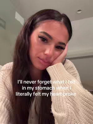 A close-up shot of a woman with dark hair holding her face with her hand, looking down with a sad expression, and text overlayed on the image.