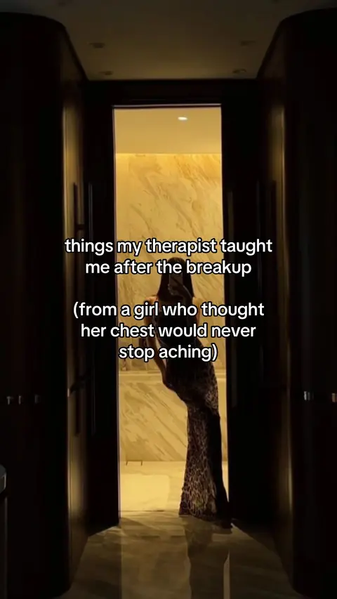 The cover image shows a woman silhouetted in a doorway, with text overlays. The woman is standing in an illuminated doorway with a marble-like background behind her, a long dress, and a dark figure holding a phone to take a selfie. The text overlays are white and placed at the top of the image describing a therapist and a breakup.