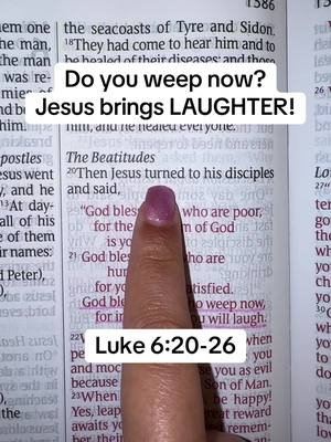 The image shows a person's index finger pointing at a page of a Bible, with highlighted text and overlaid text. The finger has a magenta nail polish. The background is the open page of a book, with printed text visible.