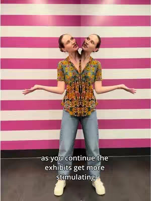 A split image of a woman with two heads standing in front of a pink and white striped background. The woman is wearing a patterned top, jeans, and white sneakers. Her arms are outstretched to the sides, and her smile is slightly quizzical. Text overlays at the bottom of the image.