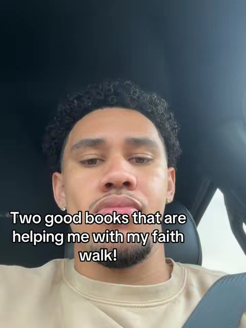 A man sits in the front seat of a car, likely filming himself. The image is well-lit with a medium shot of the man's face and upper body. Text appears on the image, overlayed in a sans-serif white font, and reads, \"Two good books that are helping me with my faith walk!\"