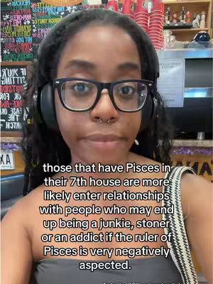 A woman with dark hair, glasses, and headphones looks directly at the camera. Text floats above her, overlaying the image. She appears to be in a cafe setting.