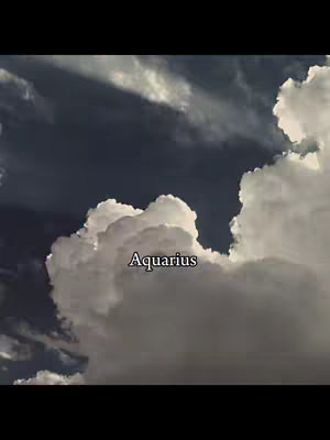 A cloudy sky with a dark blue upper portion transitioning to bright white clouds in the lower part of the frame. The word 'Aquarius' is overlaid in the center.