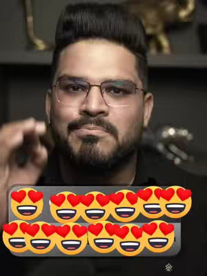 A medium shot of a man with dark hair and glasses is looking directly at the camera. He has a beard and is wearing a dark shirt. A set of animated emojis, each featuring a yellow face with heart-shaped eyes and a smiling mouth, is overlaid on the image.