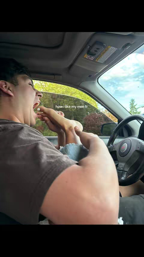 A man in a car, leaning back with his mouth open as though he is about to eat a foot. The foot belongs to someone out of frame. The hook is below the foot as its label