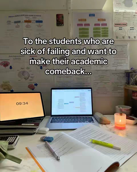 A well-lit desk setup with studying materials. On the desk are a laptop and an iPad, showing a spreadsheet and a timer. There are also open books, papers, a pen, and a highlighter. The backdrop includes charts and diagrams on a wall. A lit candle adds warmth to the scene.