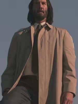 The image features Keanu Reeves in a low-angle shot. He has long dark hair, a beard, and is wearing a light brown trench coat over a white shirt and black tie. He is standing in front of a blue sky.