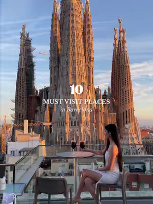 An image featuring a woman sitting on a rooftop with a view of the Sagrada Familia in Barcelona. The woman is dressed in white and is holding a glass of wine. The image is framed with the building in the background, and text overlayed about a list of places to visit.