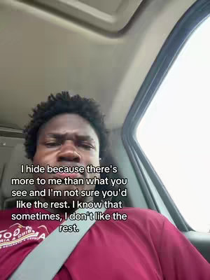 The cover image is a selfie taken inside a car. The main subject is a young Black man with short, dark, curly hair. He's seated, with the car's interior visible in the background—specifically, the ceiling and a car window, suggesting movement. He is captured from the chest up, wearing a maroon shirt and a seatbelt. His expression is one of apparent seriousness or slight annoyance. The image has text overlaid over on the lower part of the image. The text uses a casual, personal tone.